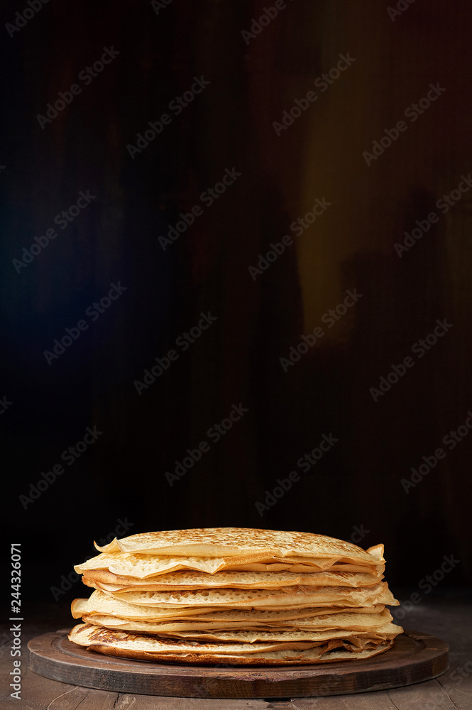 Stack of russian pancake blini on a wooden background