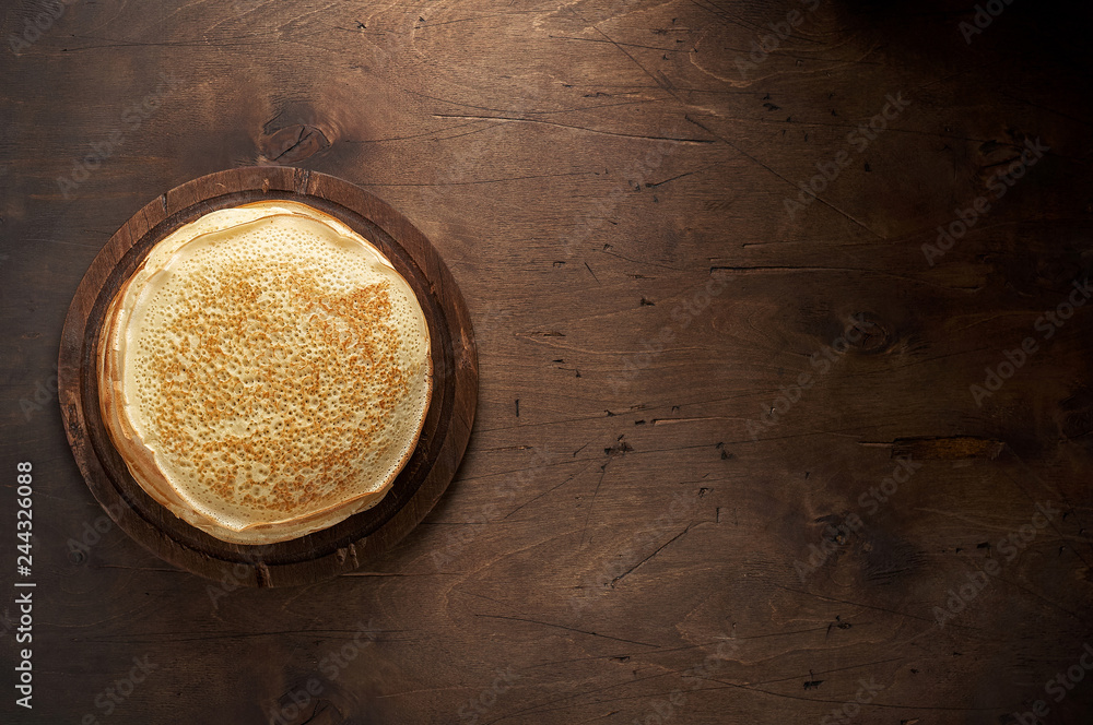 Stack of russian pancake blini on a wooden background