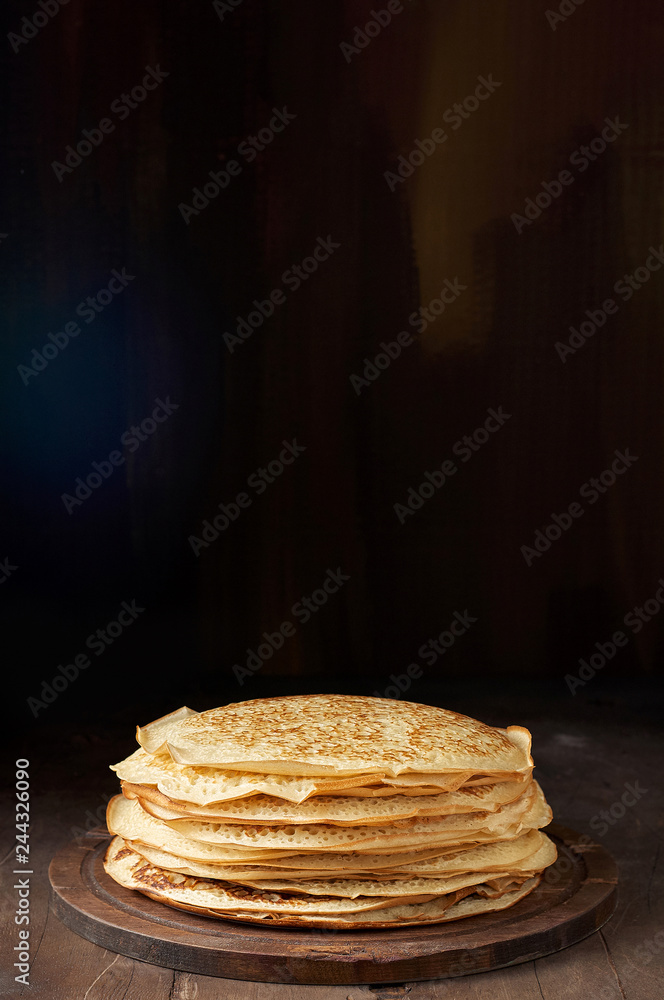 Stack of russian pancake blini on a wooden background