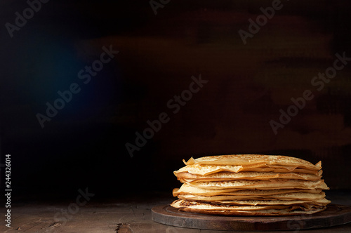 Stack of russian pancake blini on a wooden background