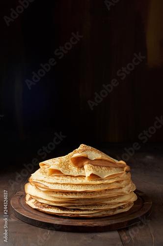 Stack of russian pancake blini on a wooden background
