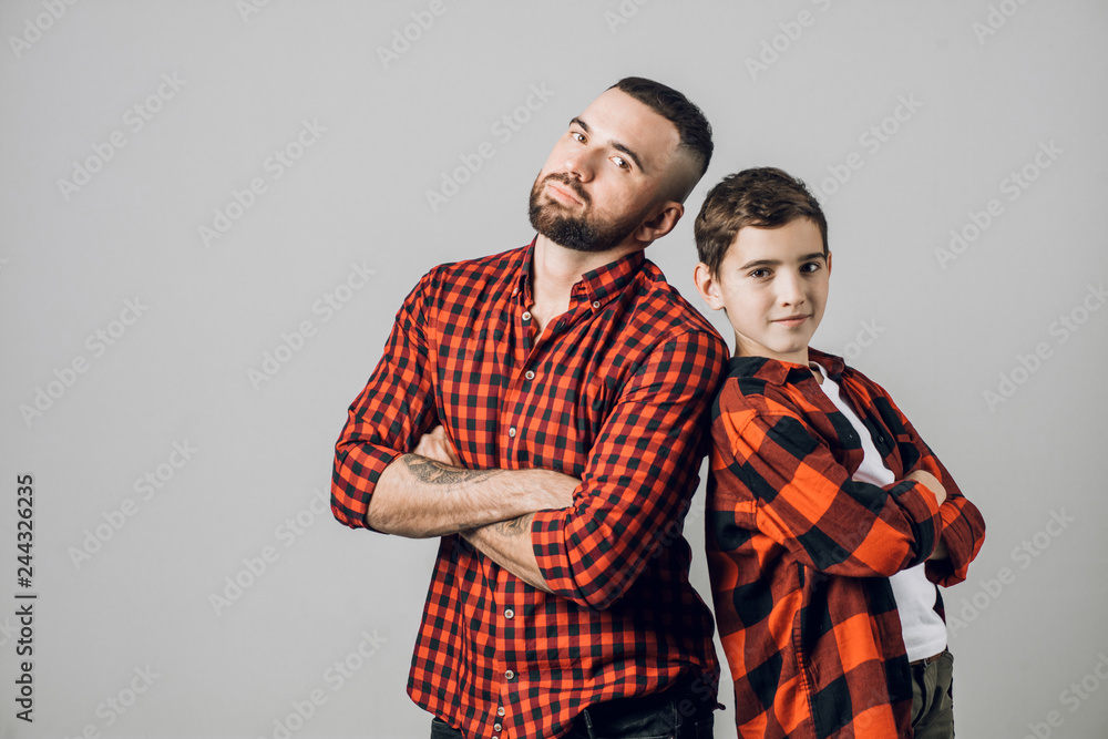 A Father and son standing with crossed arms , isolated on grey background. close up shot. friendship, communication skills A Father and son standing with crossed arms , isolated on grey background. close up shot. friendship, communication skills