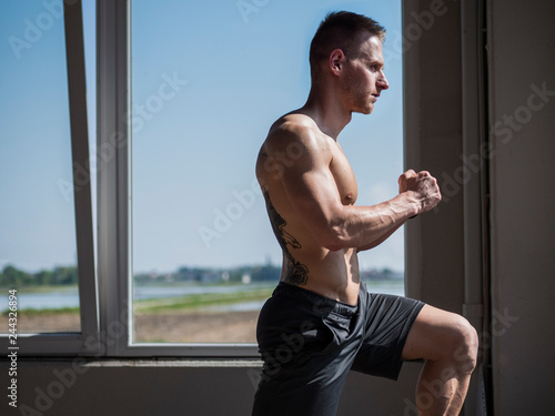 Young aerobics male coach shirtless leaning on step in gym © theartofphoto