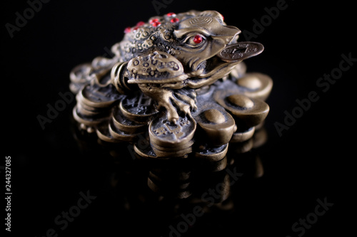 three legged toad isolated on black background. feng shui symbol