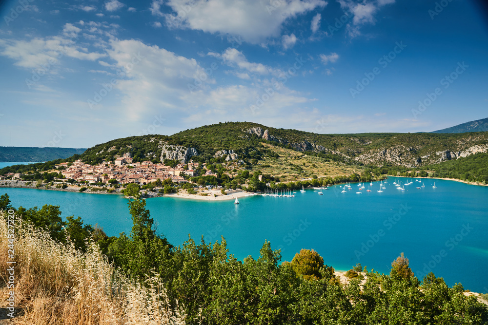The city on the bank of the artificial lake in France, Provence, lake Saint Cross, gorge Verdone,  azure water of the lake and slopes of mountains on a background, small boats, vacations place