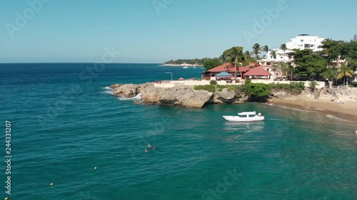 Flight over the ocean coast rifs and hotels and people on vacation, the yacht sails from the shore photo