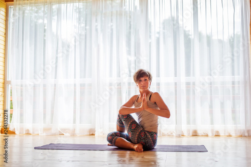 Caucasian woman is practicing yoga at studio