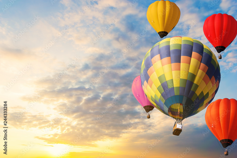 Obraz premium Colorful balloons floating in the sky at sunset.