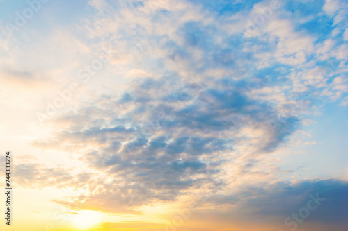 Sky blue and orange light of the sun through the clouds in the sky