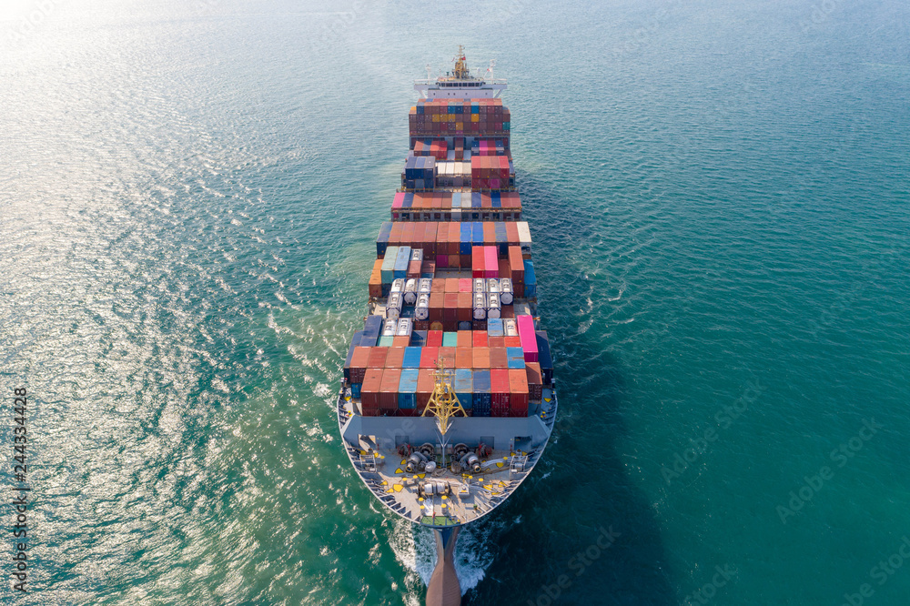 Fototapeta premium Aerial view. Container ship in pier with crane bridge carries out export and import business in the open sea. Logistics and transportation