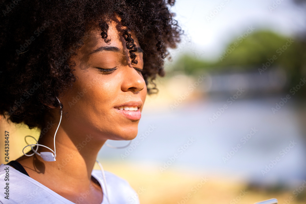Close up portrait of an attractive african brazilian woman smiling outdoors - Imagem Close up portrait of an attractive african brazilian woman smiling outdoors - Imagem