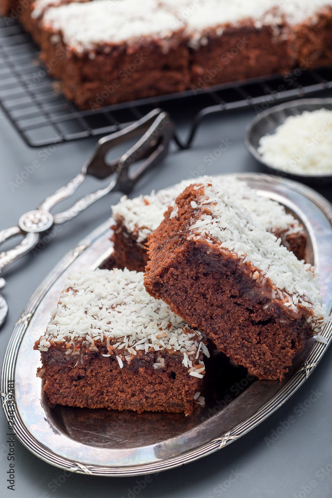 Homemade brownie with coconut flakes, swedish dessert Karleksmums, cut in square servings, vertical Homemade brownie with coconut flakes, swedish dessert Karleksmums, cut in square servings, vertical