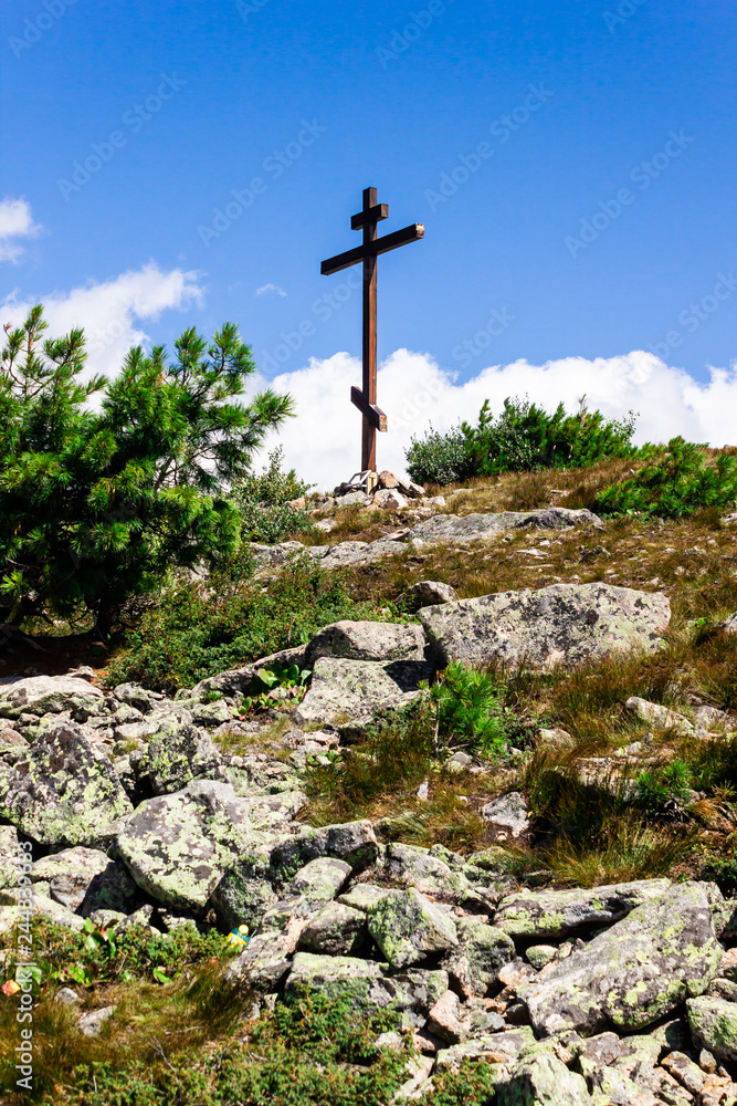 Orthodox wooden cross on mountain. Symbol of faith, pilgrimage to holy place.