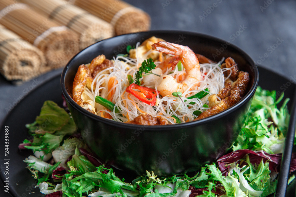 Asian salad with rice noodles with shrimps and vegetables closeup. Asian salad with rice noodles with shrimps and vegetables closeup.