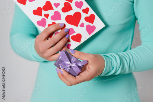 female hands hold a valentine in the form of a paper heart. Valentine's Day.