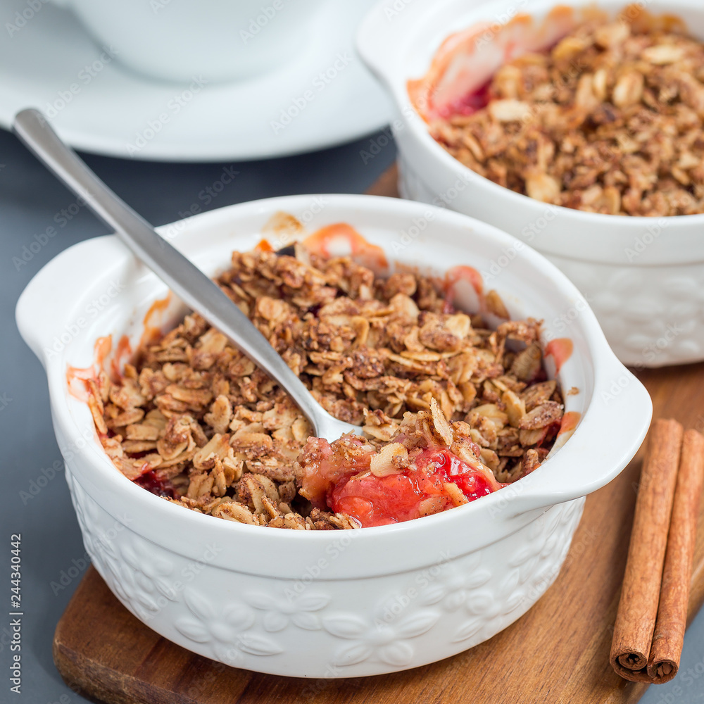 Plum crumble pie or plum crisp with oats and spices, in baking dish, square format Plum crumble pie or plum crisp with oats and spices, in baking dish, square format