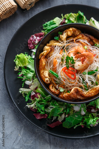 Photography Asian salad with rice noodles with shrimps and vegetables closeup