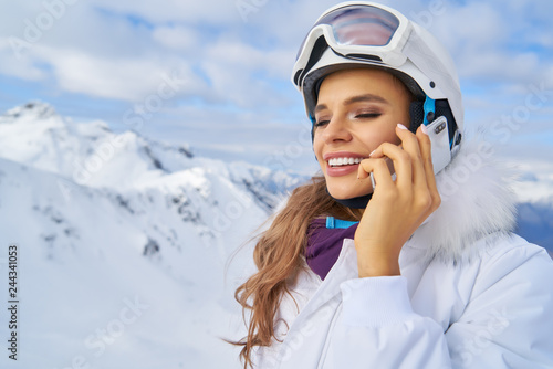 Woman talk by phone on mounting ski resort
