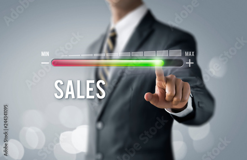 Sales growth, increase sales or business growth concept. Businessman is pulling up progress bar with the word SALES on bright tone background.