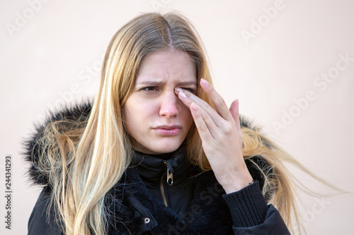 Woman with eye problems outside in winter