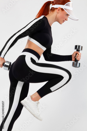 Sporty fit woman, athlete with dumbbells makes fitness exercising on white background.