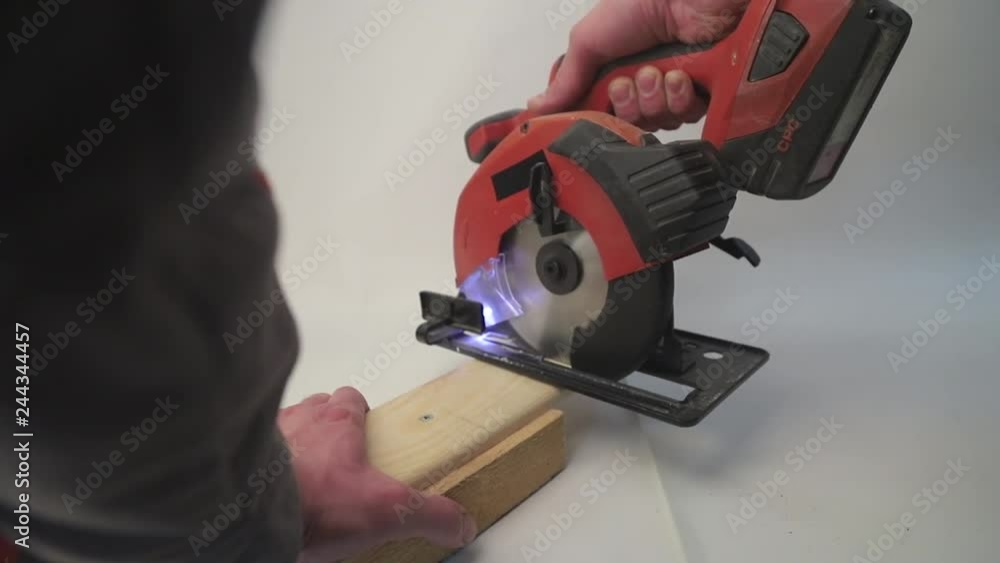cutting a piece of wood using a hand-held circular saw cutting a piece of wood using a hand-held circular saw