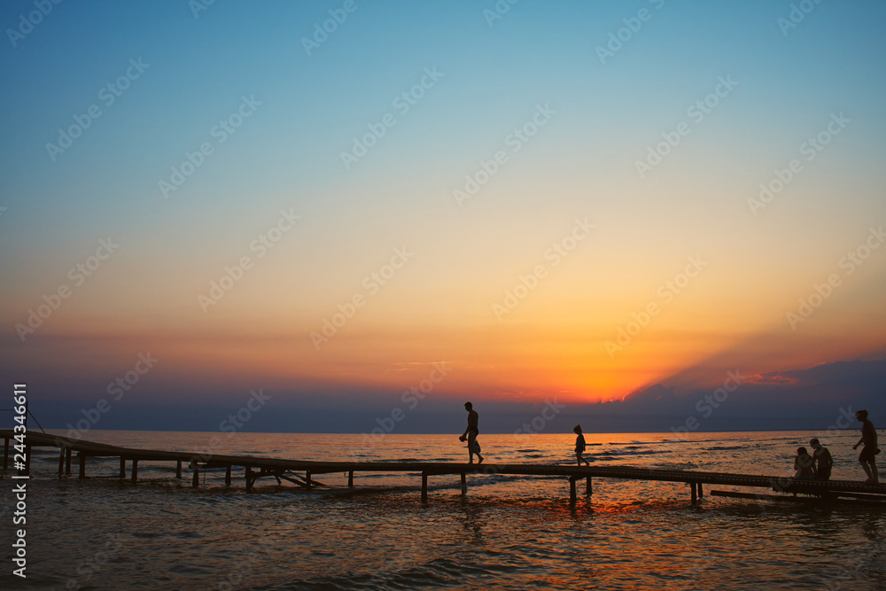 Silhouettes of People on the Pier at Dusk