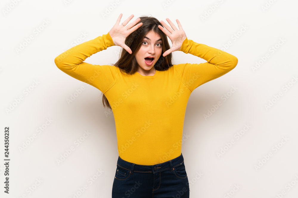 Young woman with yellow sweater with surprise and shocked facial expression Young woman with yellow sweater with surprise and shocked facial expression