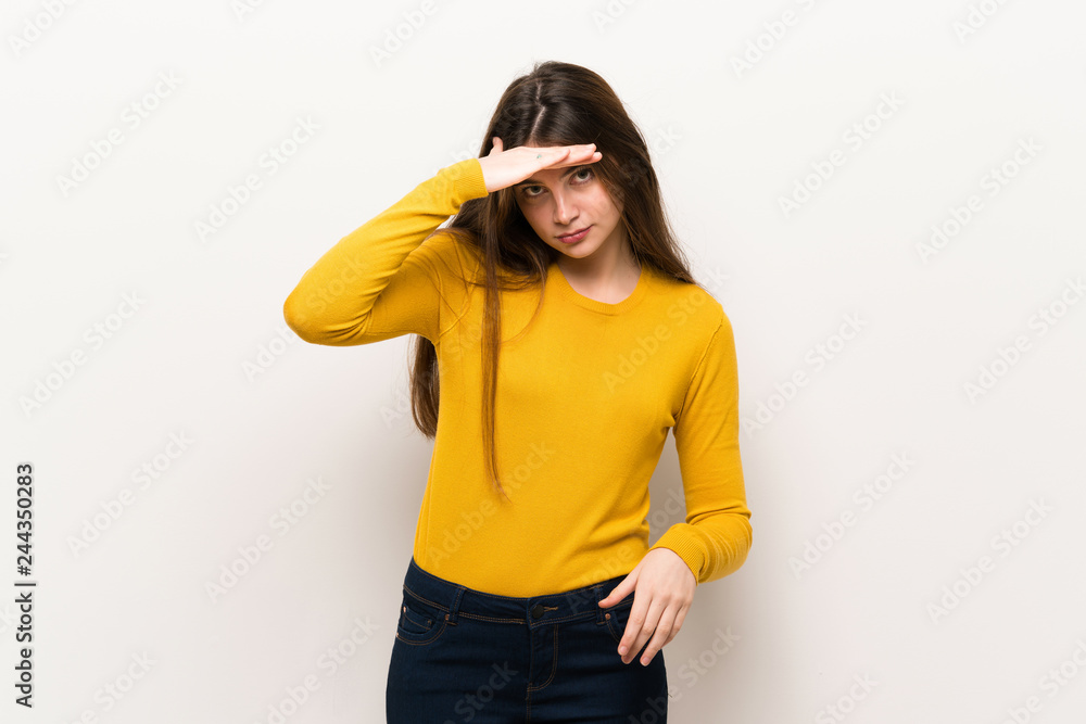 Young woman with yellow sweater looking far away with hand to look something Young woman with yellow sweater looking far away with hand to look something