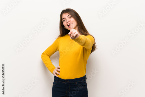 Young woman with yellow sweater showing and lifting a finger