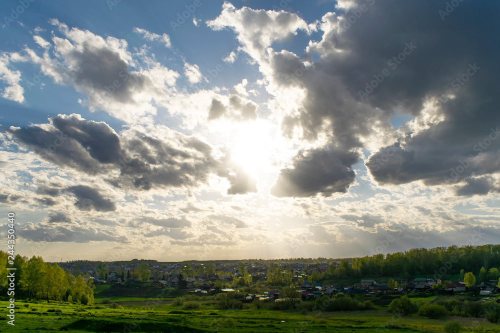 The sun shines through the clouds in the countryside near the forest The sun shines through the clouds in the countryside near the forest