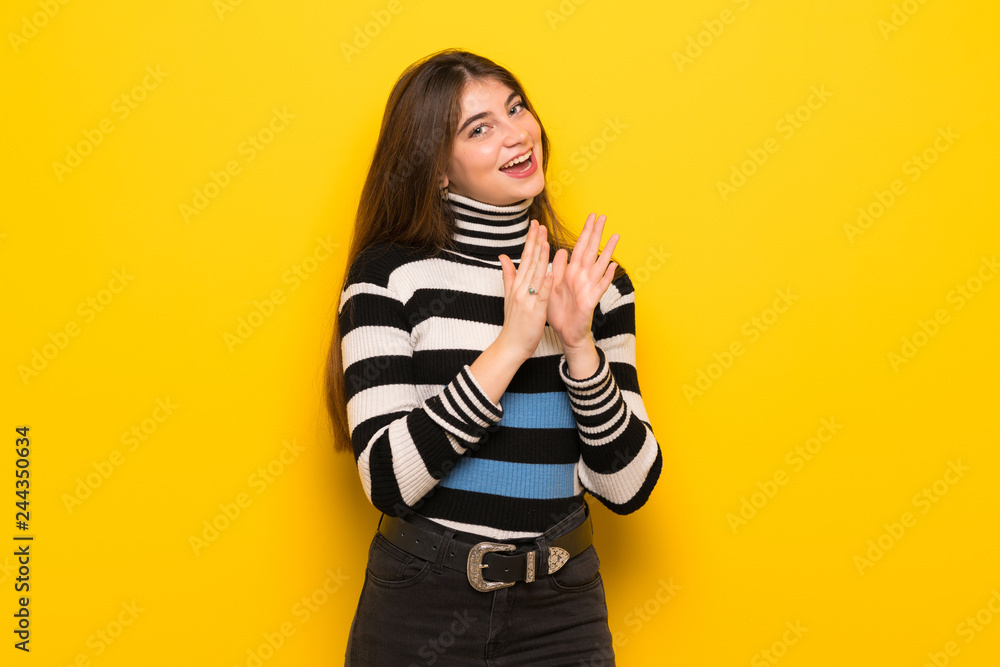Young woman over yellow wall applauding after presentation in a conference Young woman over yellow wall applauding after presentation in a conference