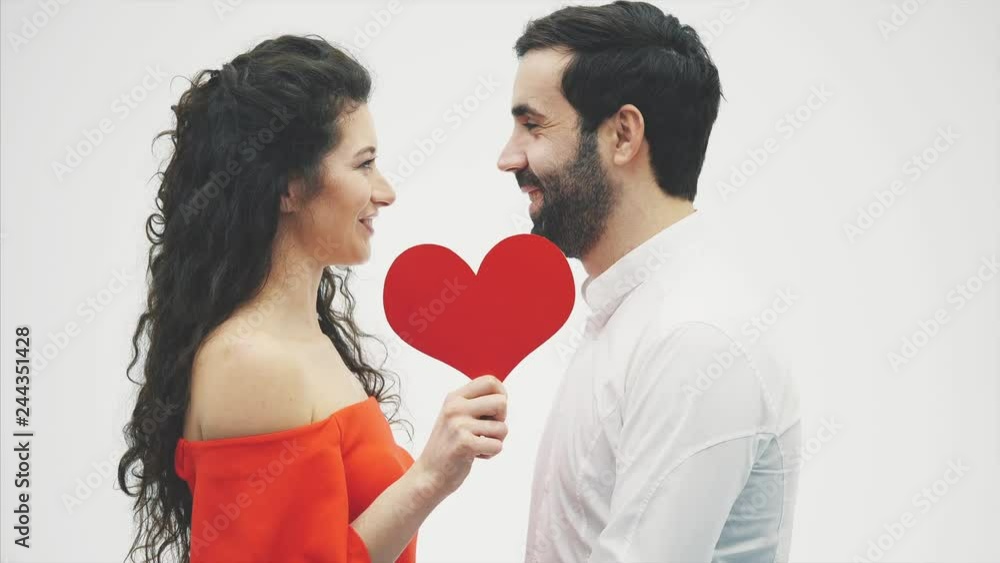 Beautiful romantic couple isolated on white background. Attractive young woman and handsome hand hug with red heart. Happy Valentine Kiss.