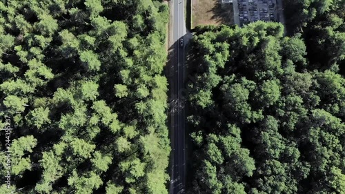 Aerial reveal shot and flight over of a French village near a road in the forest taken from a drone