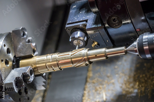 The CNC lathe machine cutting the slot groove at the brass shaft .Hi-technology automotive part manufacturing process.