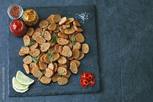 Rye crackers on a stone board with spices and sauce