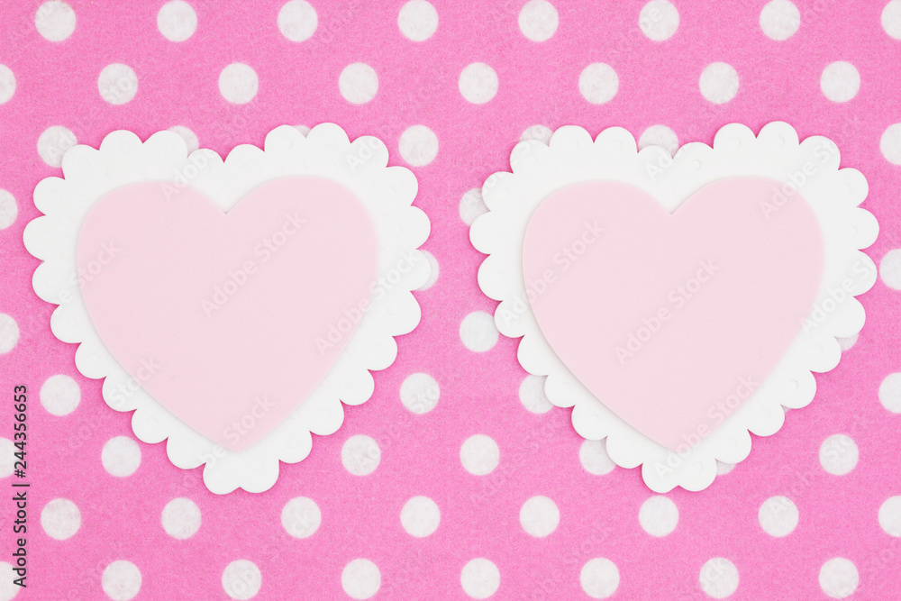 Two blank white and pink hearts on bright pink and white polka dot fabric background