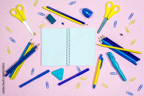 Set of multicolored office supplies on a pink background. photo