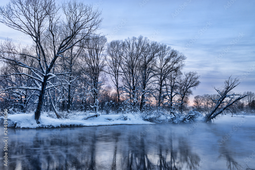 Snowy frozen landscape of sunrise on lakeside with trees Snowy frozen landscape of sunrise on lakeside with trees