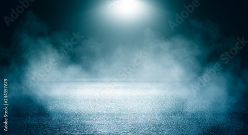 Black background of empty street, room, blue searchlight illuminates asphalt, smoke