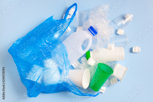 Various plastic garbage on the light blue background