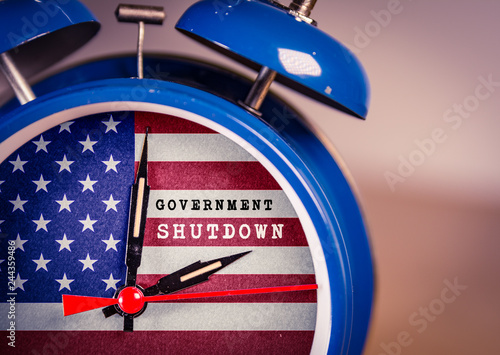 Retro alarm Clock with Government Shutdown text,and American Flag. USA shutdown, government closed and American federal shut down due to spending bill disagreement between the left and the right