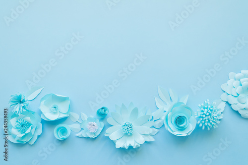 Different blue paper flowers on blue background