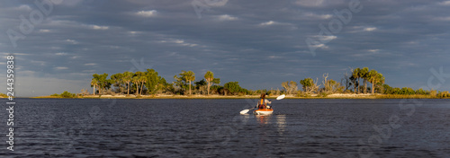 Fotografie Panorama of woman kayaking in the Gulf of Mexico with birds flying overhead