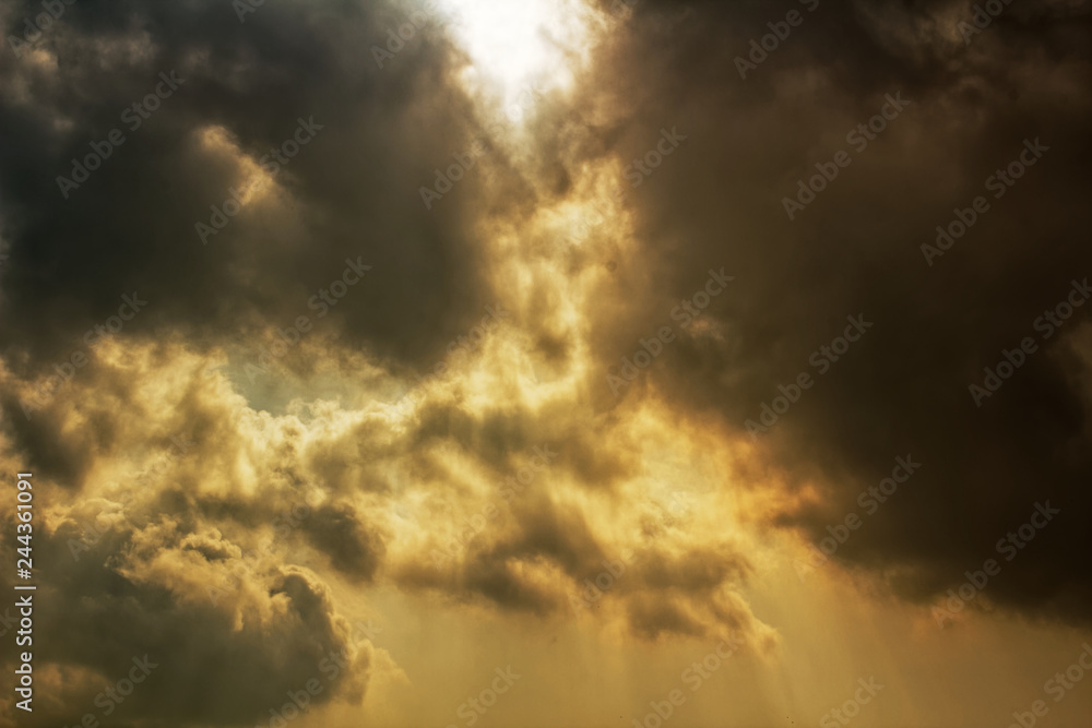 Rays of sunlight shining through dark storm clouds - dramatic apocalyptic effect