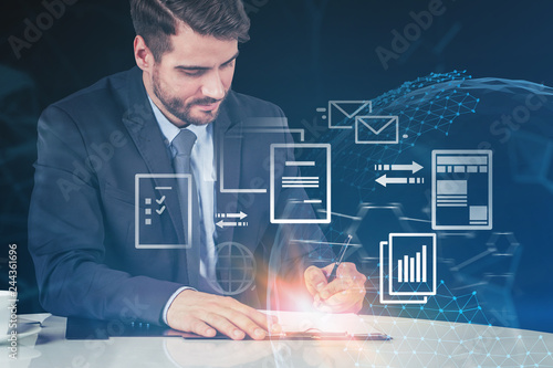 Businessman writing in office, electronic document photo