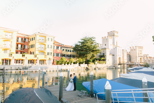 Amazing pictorial view with Rocca Scaligera in Sirmione. Italy and young couple in love walking and posing © sofiko14