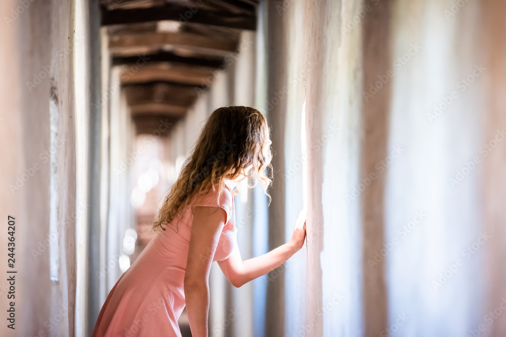 Fortress tunnel path passage in Castiglione del Lago in Italy during summer with woman looking out of window in historic town village fort Fortress tunnel path passage in Castiglione del Lago in Italy during summer with woman looking out of window in historic town village fort