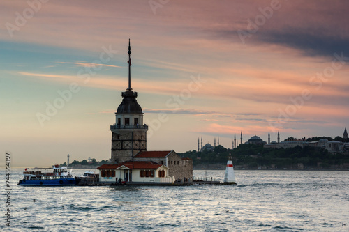Beautiful landscape of Maiden's tower (Tower of Leandros) at sunset. View of Dramatic cloudy sky. In the distance are such landmarks as Hagia Sophia, Blue Mosque and Topkapi Palace. Istanbul. Turkey.