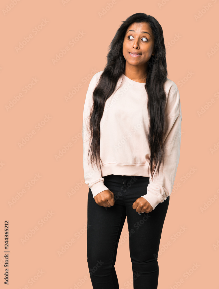 Young afro american woman is a little bit nervous and scared pressing the teeth on isolated brown background Young afro american woman is a little bit nervous and scared pressing the teeth on isolated brown background
